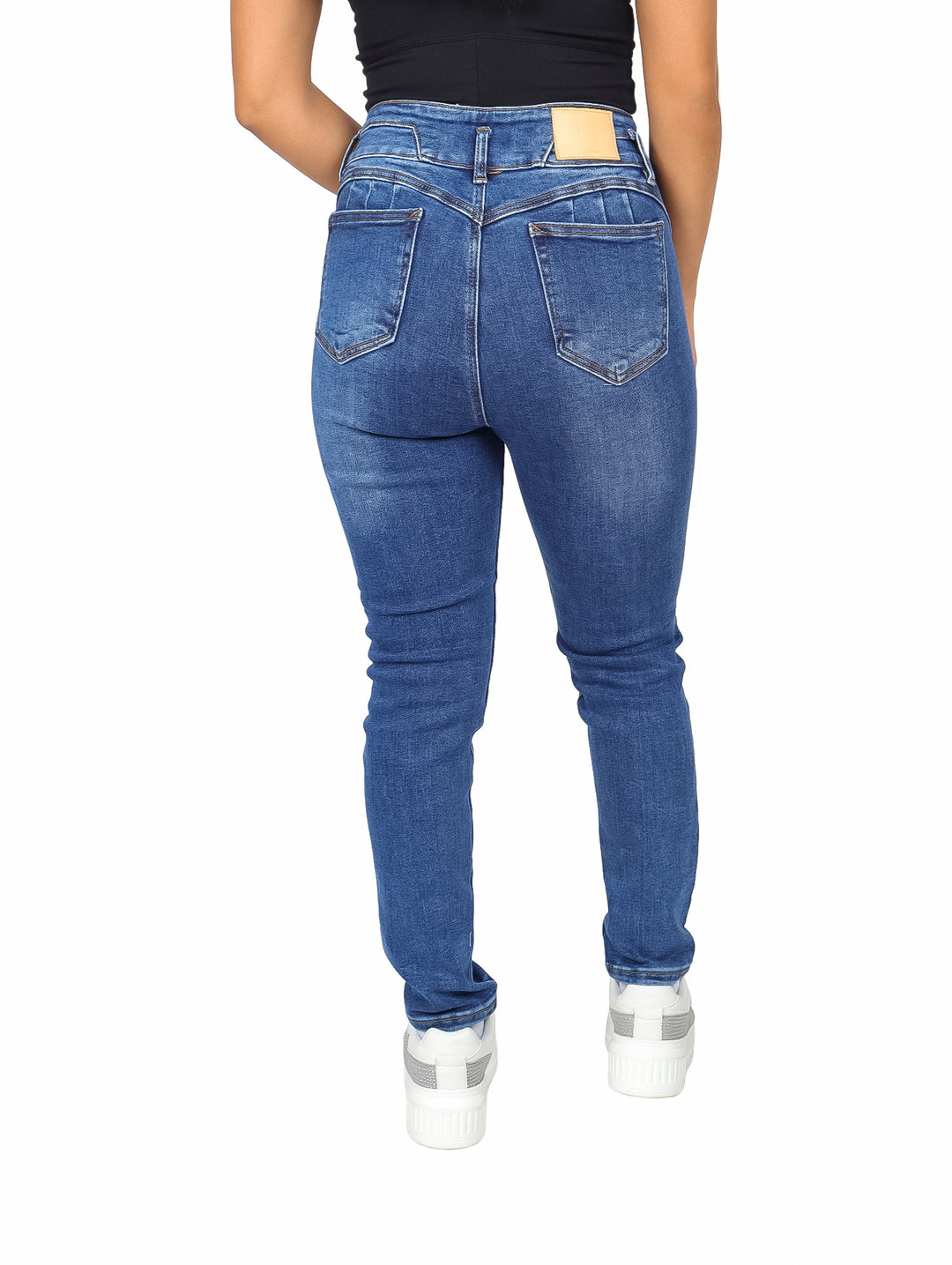 Mujer vistiendo pantalones jeans skinny de color azul con efecto de lavado stone.