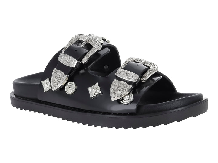 Sandalia negra para mujer con dos correas adornadas con hebillas y detalles ornamentales en color plata.