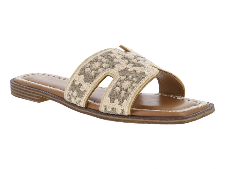 Sandalia beige con correa ancha bordada con motivos florales y suela color café.