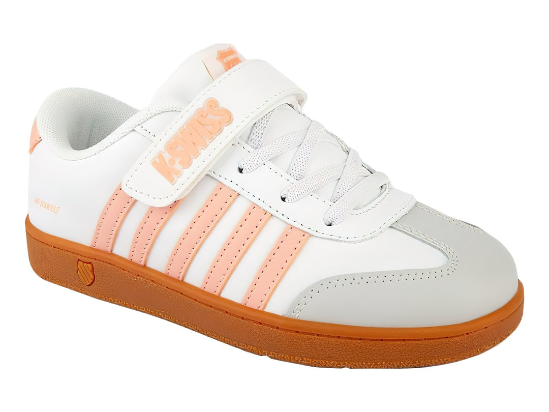 Tenis K-Swiss blancos con detalles en rosa y suela naranja, con cierre de velcro y agujetas para niños.