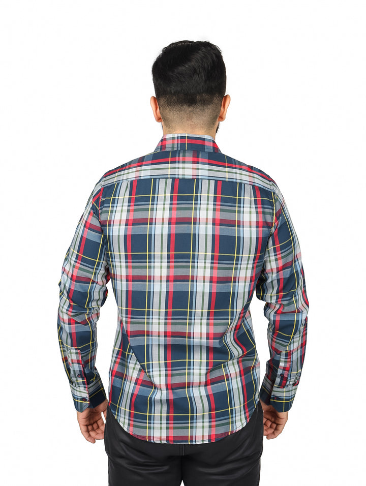 Hombre usando camisa de manga larga con estampado de cuadros en tonos gris, rojo y amarillo.
