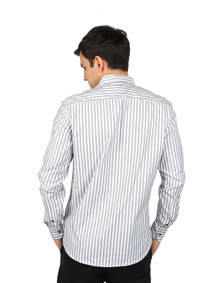 Hombre vistiendo camisa de manga larga con rayas verticales blancas y grises.