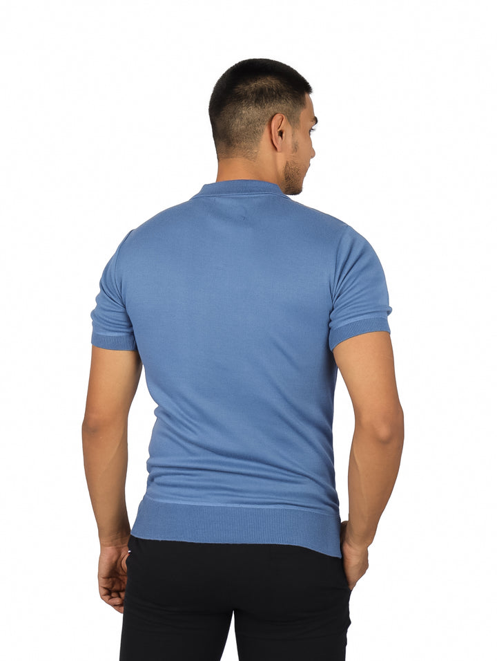 Hombre vistiendo playera polo azul con rayas verticales beige y cuello clásico.