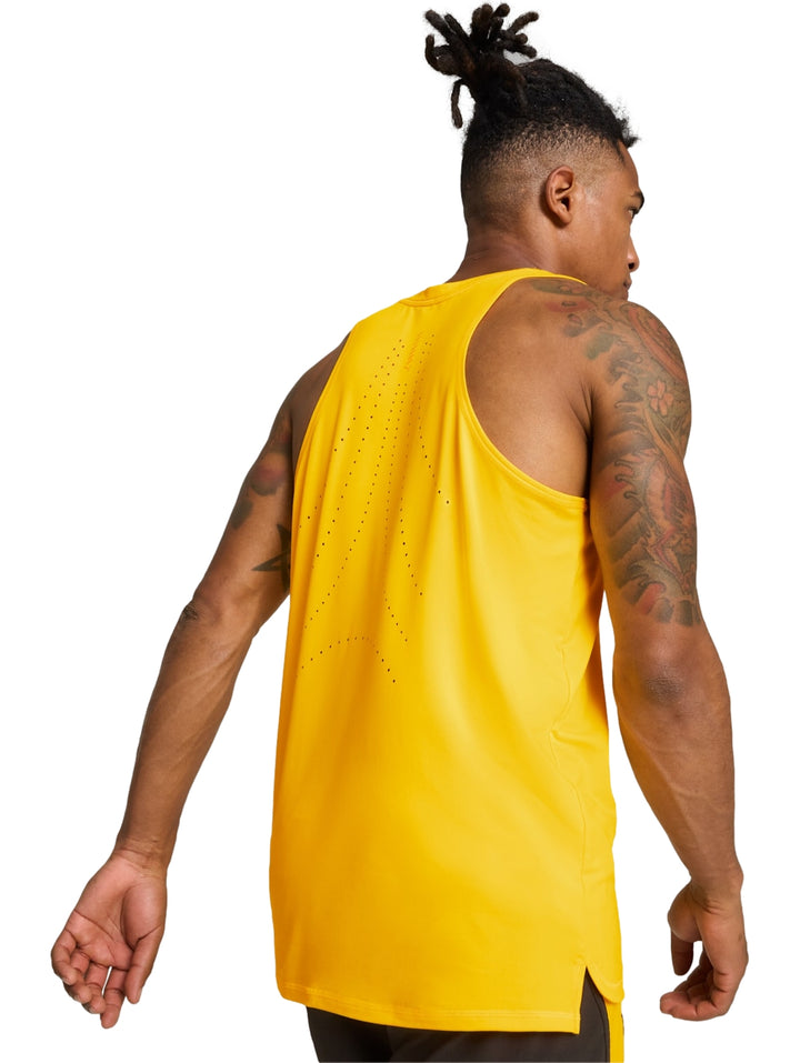 Hombre vistiendo una camiseta deportiva sin mangas de color amarillo intenso de la marca PUMA.