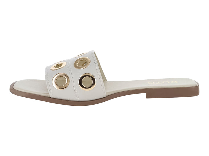 Sandalia plana color beige para mujer con detalles de orificios metálicos dorados en la banda superior.