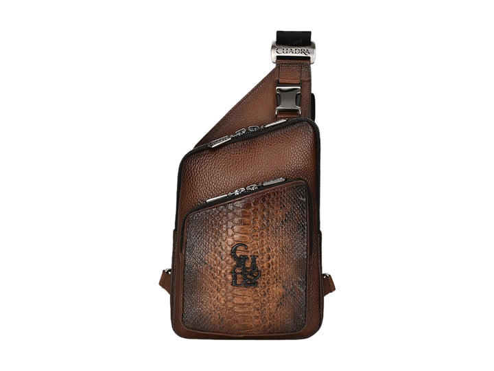Bolso bandolera Cuadra en cuero café con panel frontal de piel de pitón y herrajes metálicos.