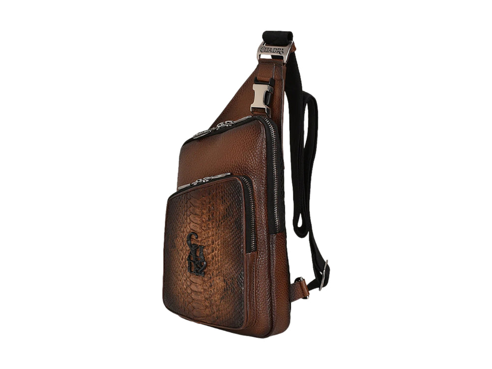 Bolso bandolera Cuadra en cuero café con panel frontal de piel de pitón y herrajes metálicos.