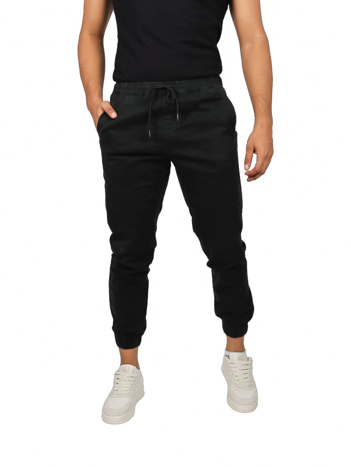 Hombre vistiendo pantalones jogger color negro con cintura elástica y puños ajustados.
