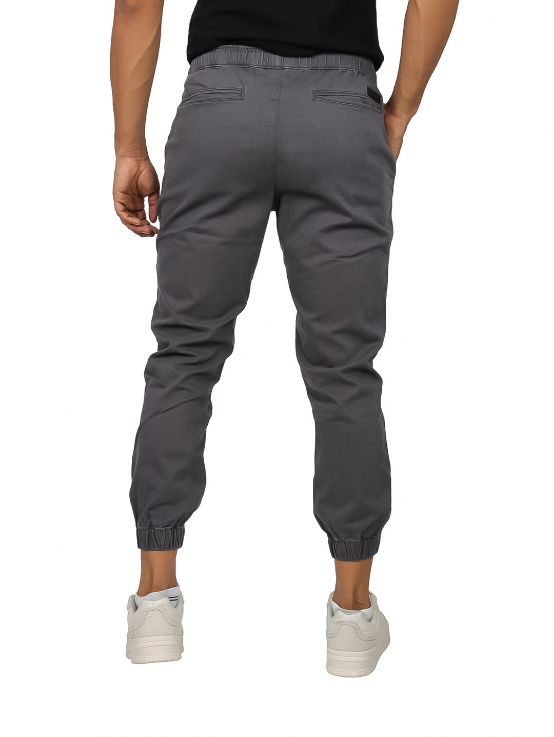 Hombre vistiendo pantalones jogger color gris oxford con cintura elástica y calzado blanco.