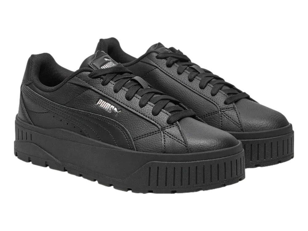 Tenis PUMA color negro con suela de plataforma gruesa y logotipo plateado en el costado.