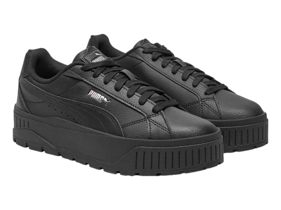 Tenis PUMA color negro con suela de plataforma gruesa y logotipo plateado en el costado.