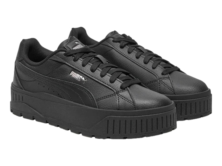Tenis PUMA color negro con suela de plataforma gruesa y logotipo plateado en el costado.