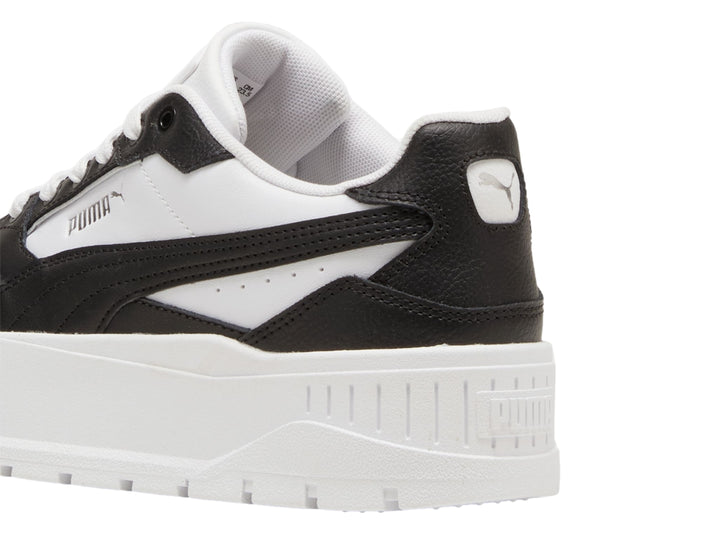 Tenis PUMA blancos y negros con suela de plataforma gruesa.