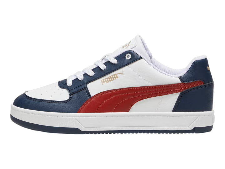 Tenis Puma Caven 2.0 color blanco con detalles en azul marino y franja roja lateral.