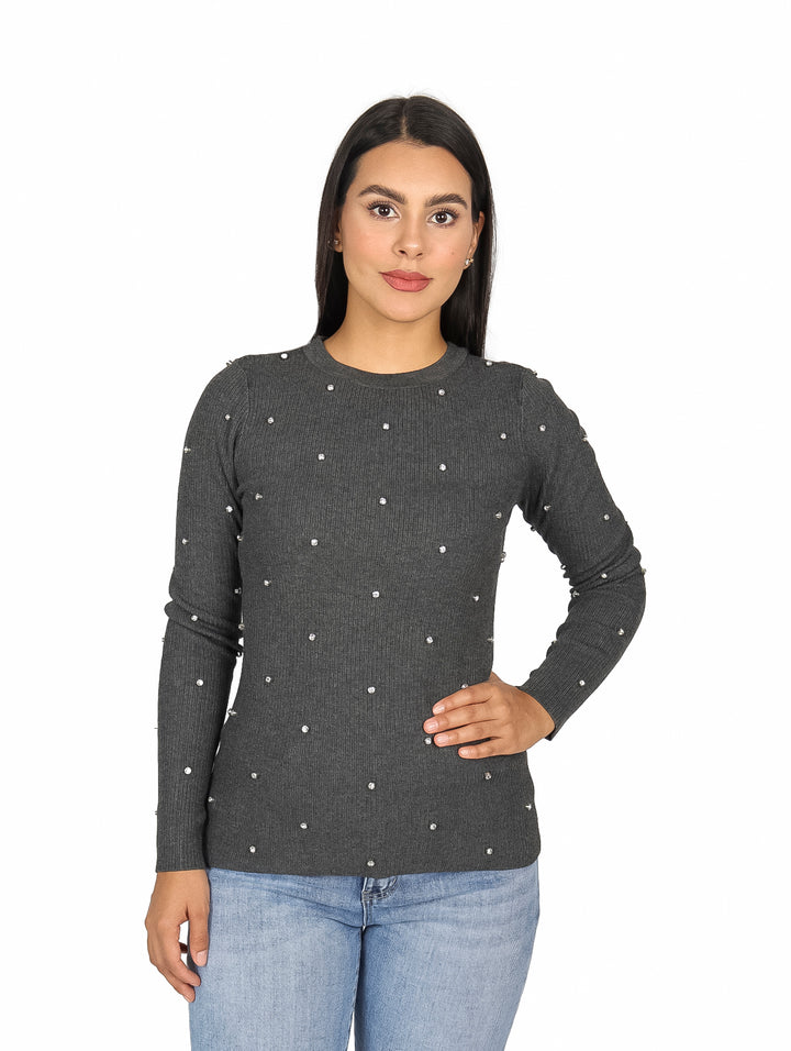 Mujer vistiendo blusa gris de manga larga con pequeños detalles de piedras blancas distribuidas en toda la prenda.
