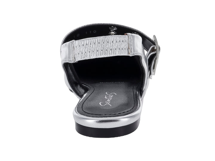 Zapato plano color plata con punta aguda, hebilla decorativa y correa posterior.