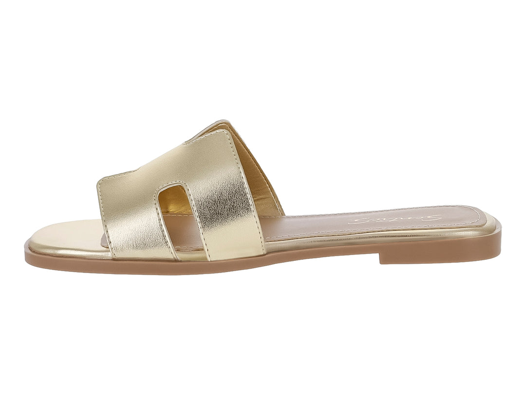 Sandalia plana para mujer en color oro metálico con tira ancha frontal y suela delgada.