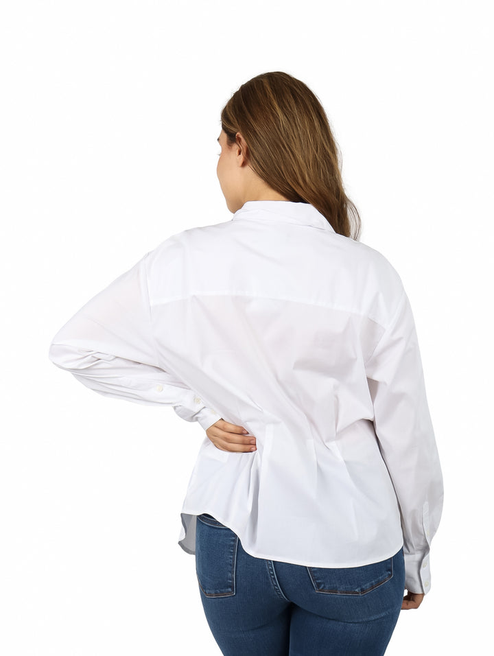 Mujer vistiendo una camisera blanca de manga larga para maternidad con cuello y botones.