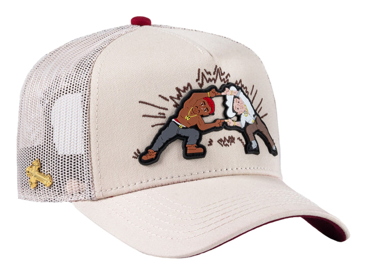 Gorra trucker beige con parche gráfico frontal y malla trasera.