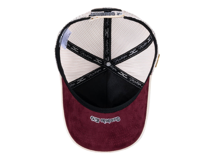 Gorra trucker beige con parche gráfico frontal y malla trasera.