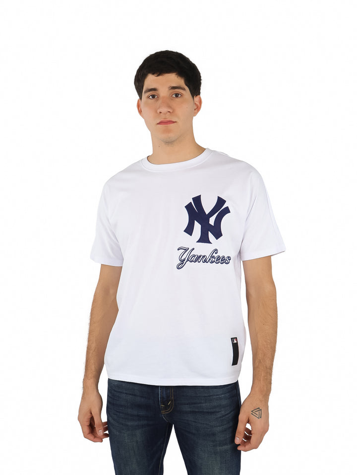Hombre vistiendo una playera blanca de manga corta con el logo de los New York Yankees en el pecho.