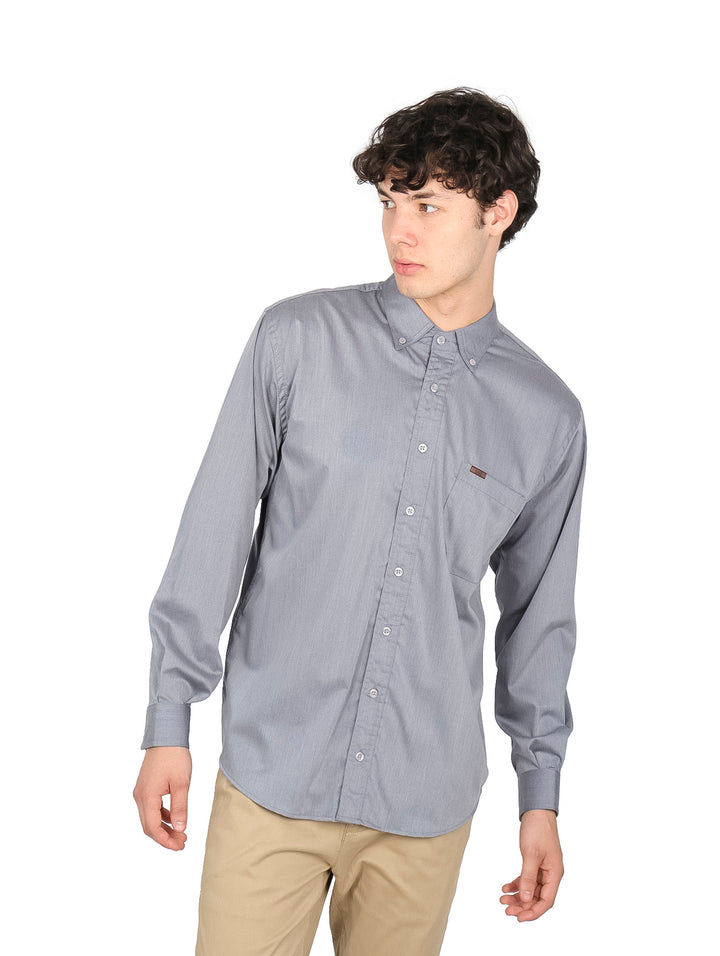 Hombre vistiendo una camisa de manga larga color gris con botones frontales.