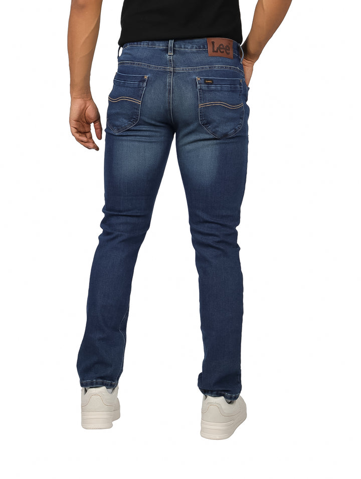 Hombre vistiendo pantalones de mezclilla color azul indigo en corte slim fit.