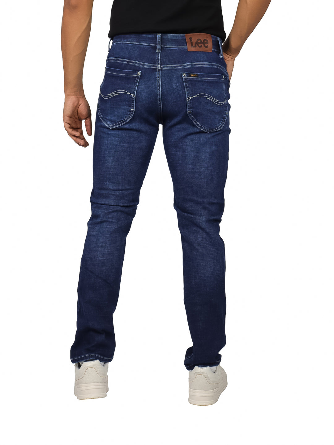 Hombre vistiendo pantalones LEE de mezclilla azul índigo en corte slim fit.