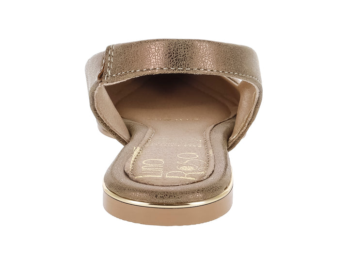 Zapato plano tipo mule para mujer en color oro inglés con acabado brillante y punta redondeada.