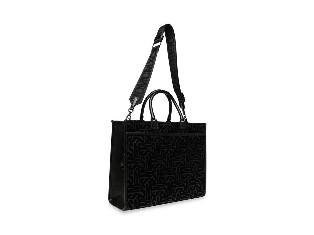 Bolso de hombro Steve Madden color negro con patrón geométrico en relieve, asas cortas y correa larga ajustable.