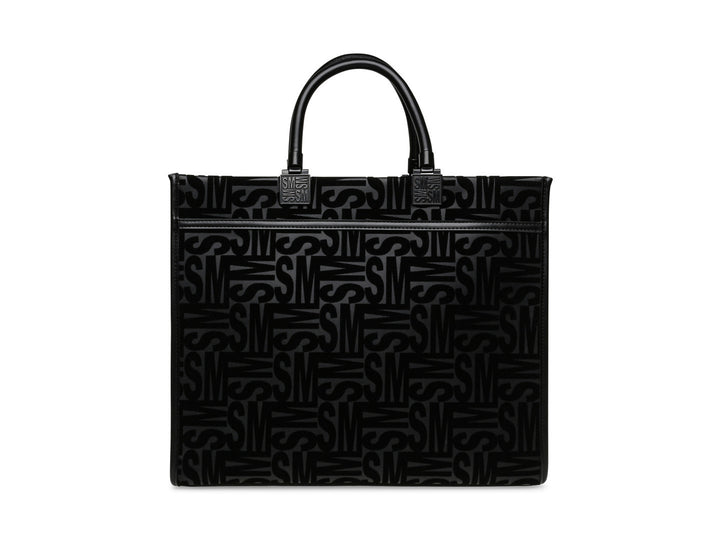 Bolso de hombro Steve Madden color negro con patrón geométrico en relieve, asas cortas y correa larga ajustable.