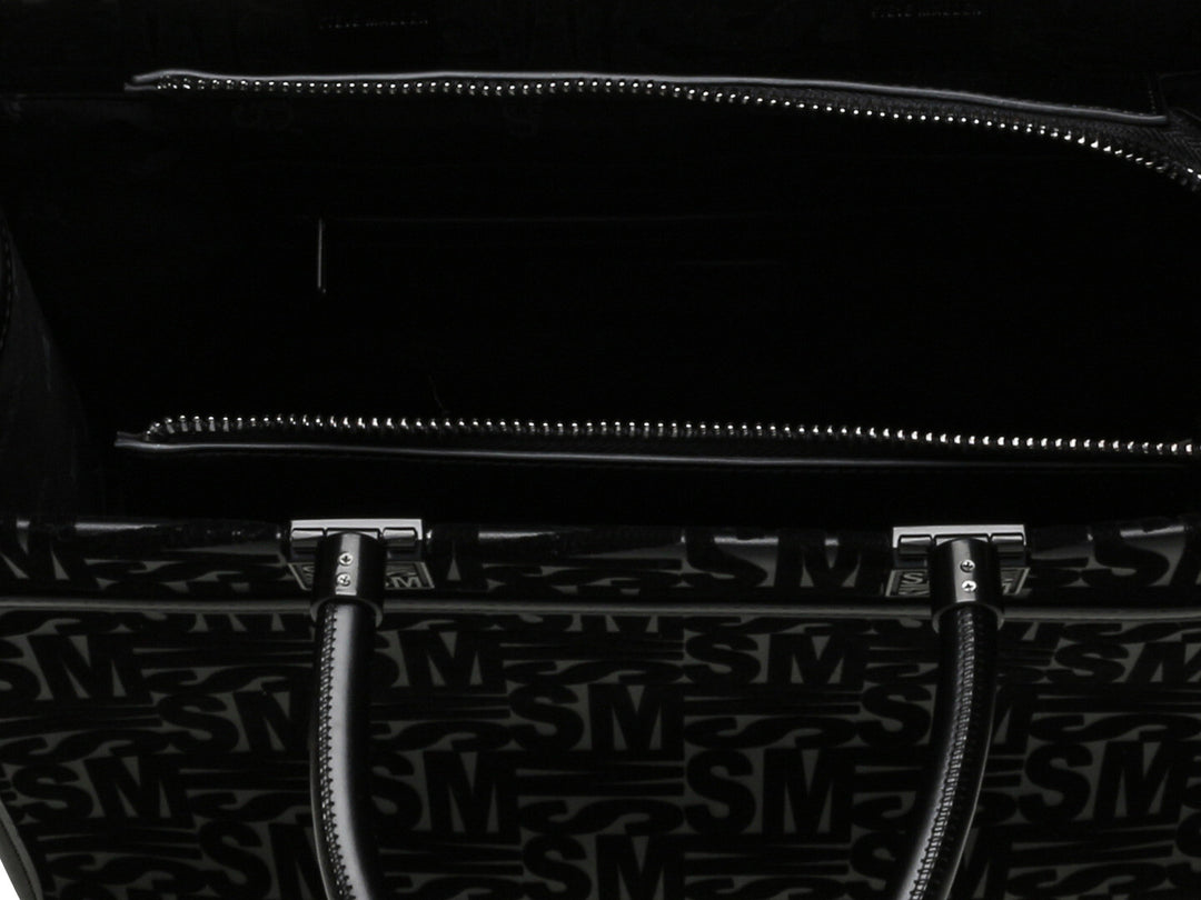 Bolso de hombro Steve Madden color negro con patrón geométrico en relieve, asas cortas y correa larga ajustable.