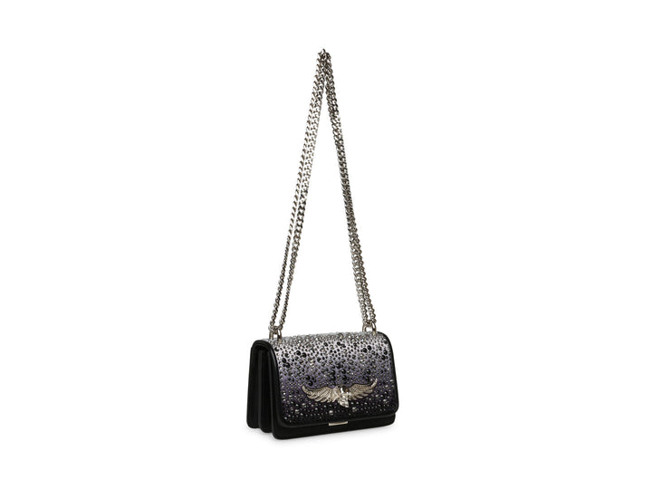 Bolso negro de Steve Madden con cadena plateada, detalles de pedrería brillante y un adorno metálico en forma de ave.