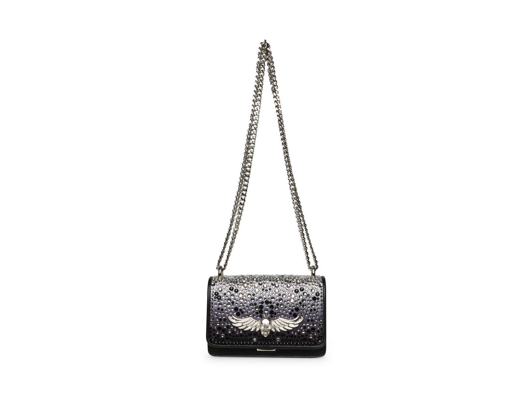 Bolso negro de Steve Madden con cadena plateada, detalles de pedrería brillante y un adorno metálico en forma de ave.