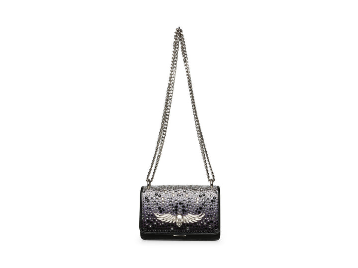 Bolso negro de Steve Madden con cadena plateada, detalles de pedrería brillante y un adorno metálico en forma de ave.