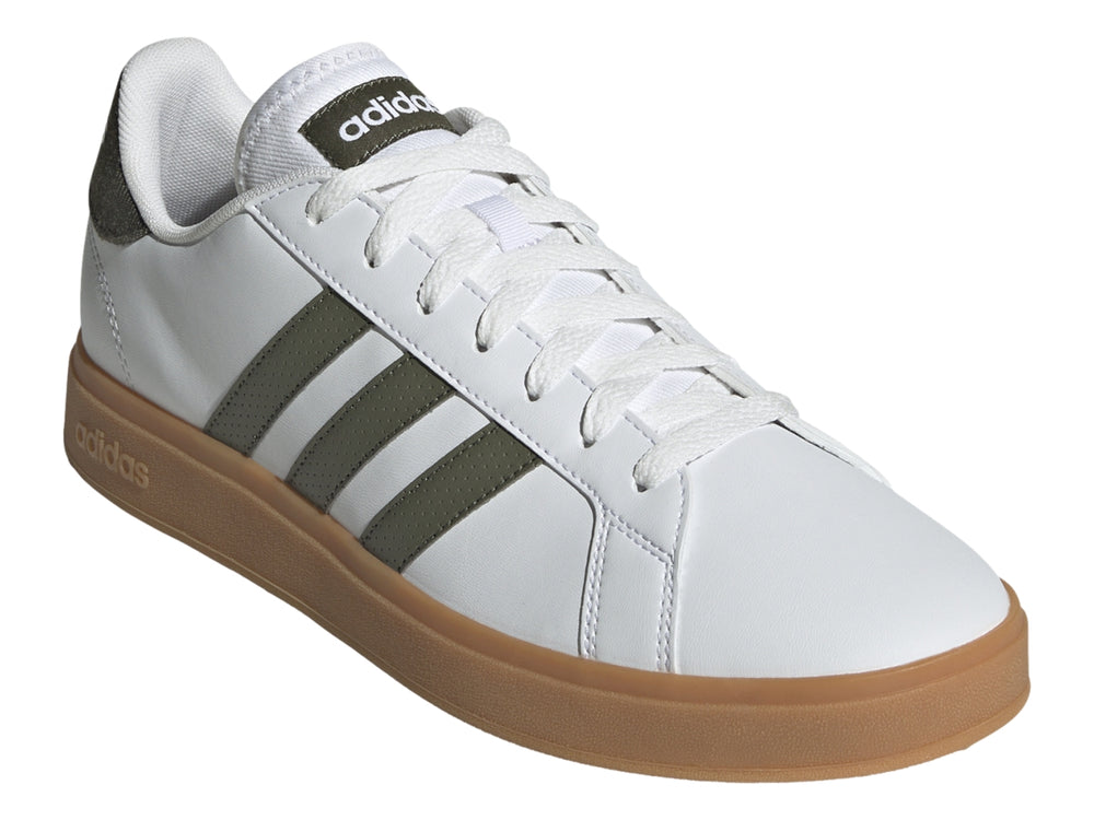 Tenis Adidas blancos con tres franjas verde oliva y suela de goma color café.