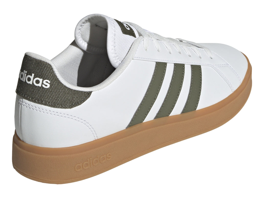 Tenis Adidas blancos con tres franjas verde oliva y suela de goma color café.
