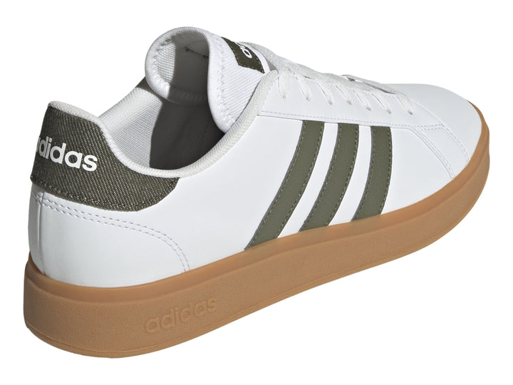 Tenis Adidas blancos con tres franjas verde oliva y suela de goma color café.