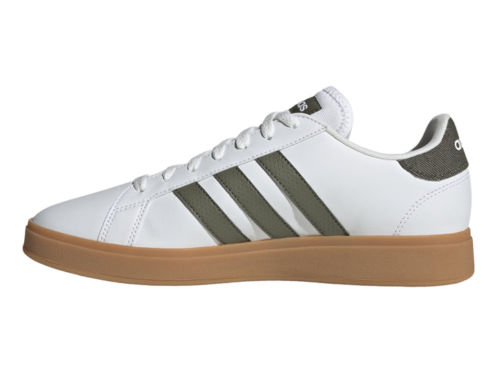Tenis Adidas blancos con tres franjas verde oliva y suela de goma color café.