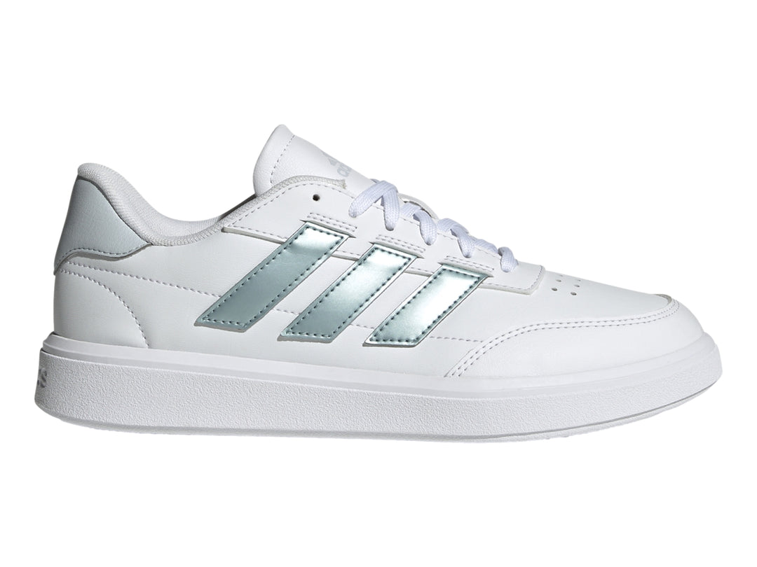 Tenis Adidas Courtblock blancos con franjas laterales plateadas y suela blanca.