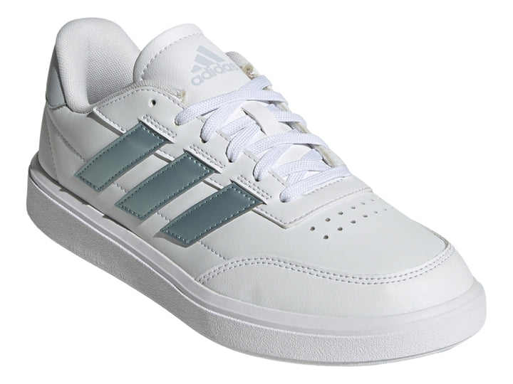 Tenis Adidas Courtblock blancos con franjas laterales plateadas y suela blanca.