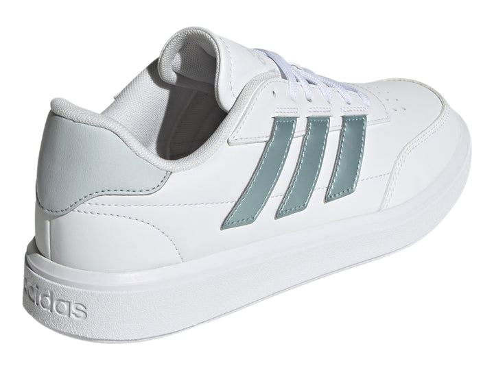 Tenis Adidas Courtblock blancos con franjas laterales plateadas y suela blanca.