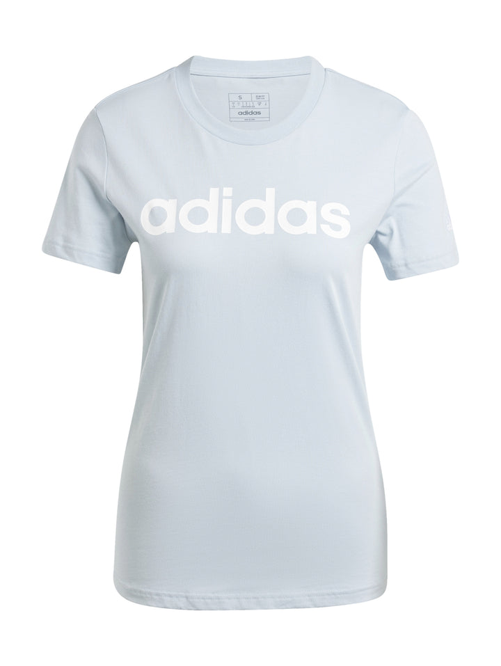 Mujer vistiendo playera ajustada y pantalones de color celeste claro con logo de Adidas en el pecho.