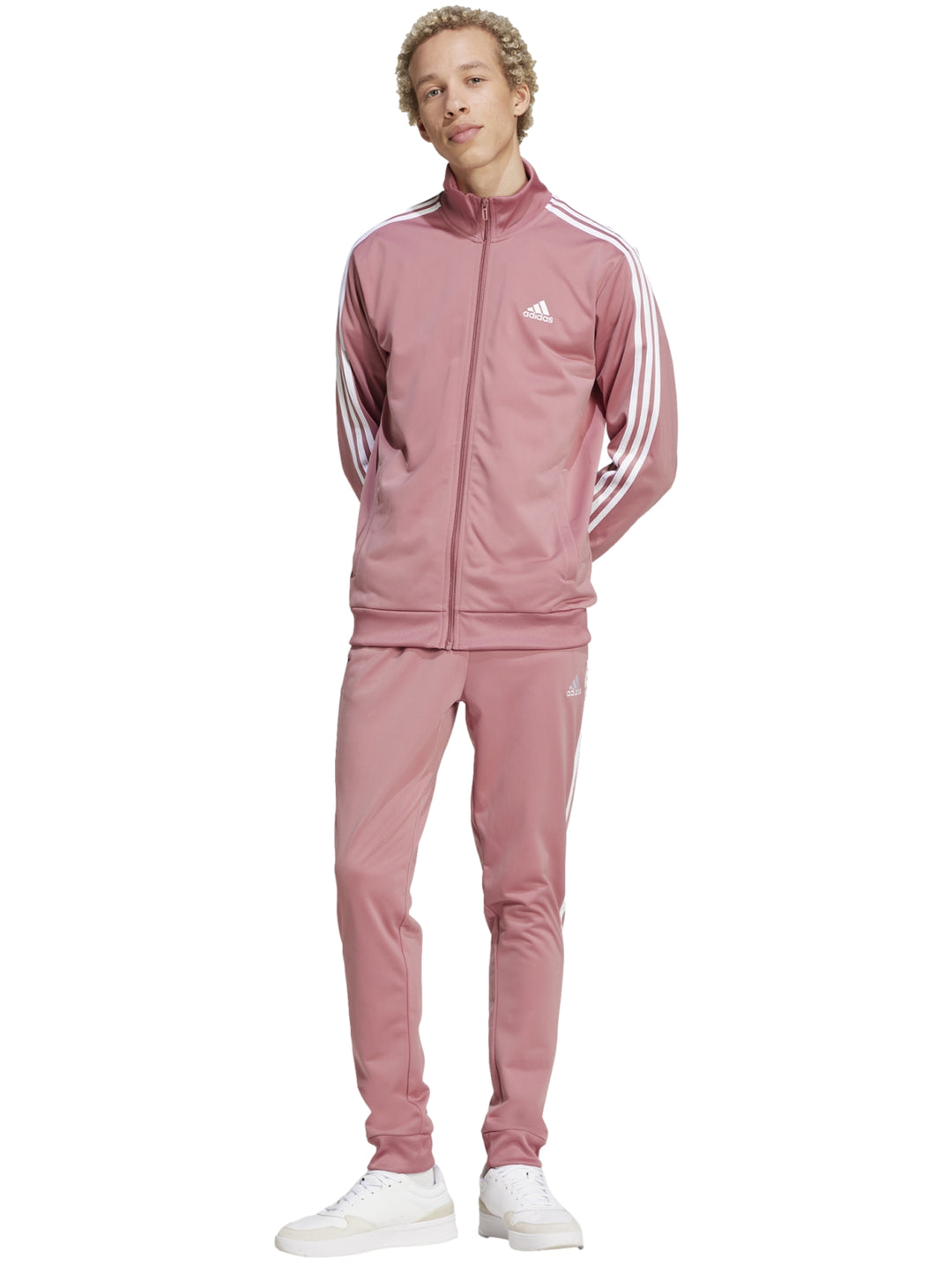 Hombre vistiendo conjunto deportivo Adidas de color rosa con tres franjas blancas laterales.
