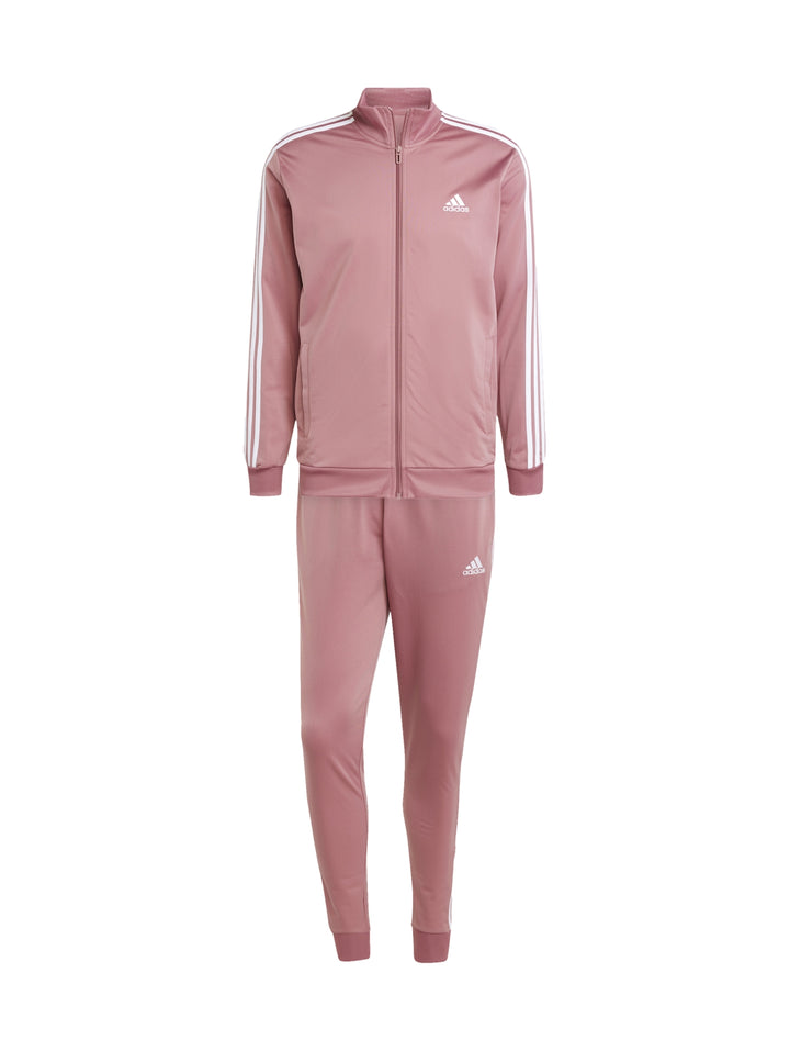 Hombre vistiendo conjunto deportivo Adidas de color rosa con tres franjas blancas laterales.
