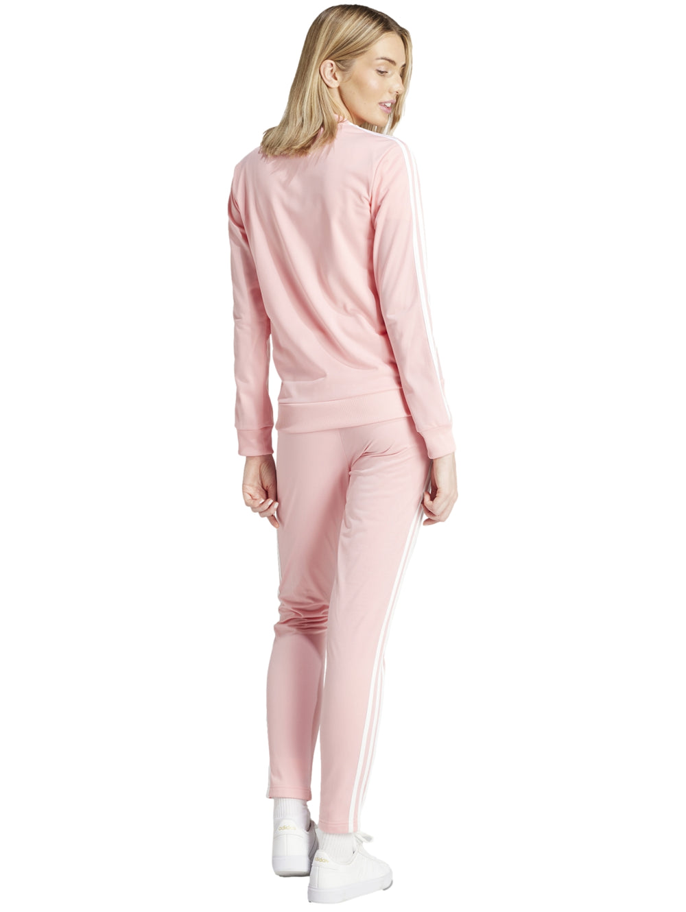 Conjunto deportivo Adidas color rosa claro con tres franjas blancas laterales, incluye chaqueta y pantalón para mujer.