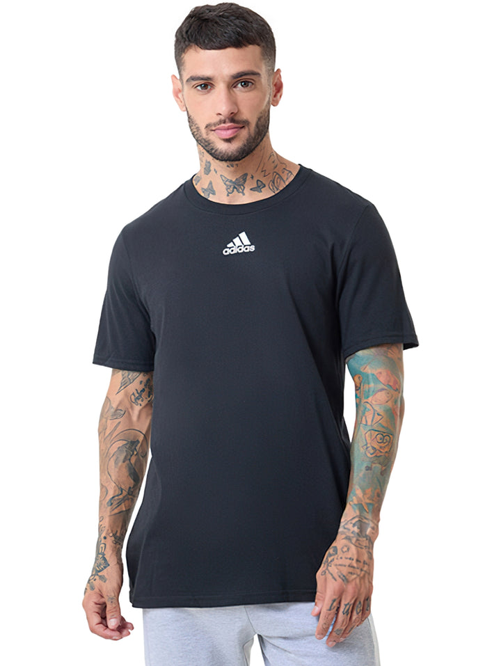 Hombre vistiendo camiseta negra de manga corta con logo pequeño de Adidas en el pecho.