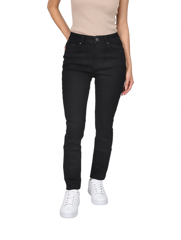 Mujer vistiendo jeans skinny de color negro con cintura alta y tenis blancos.