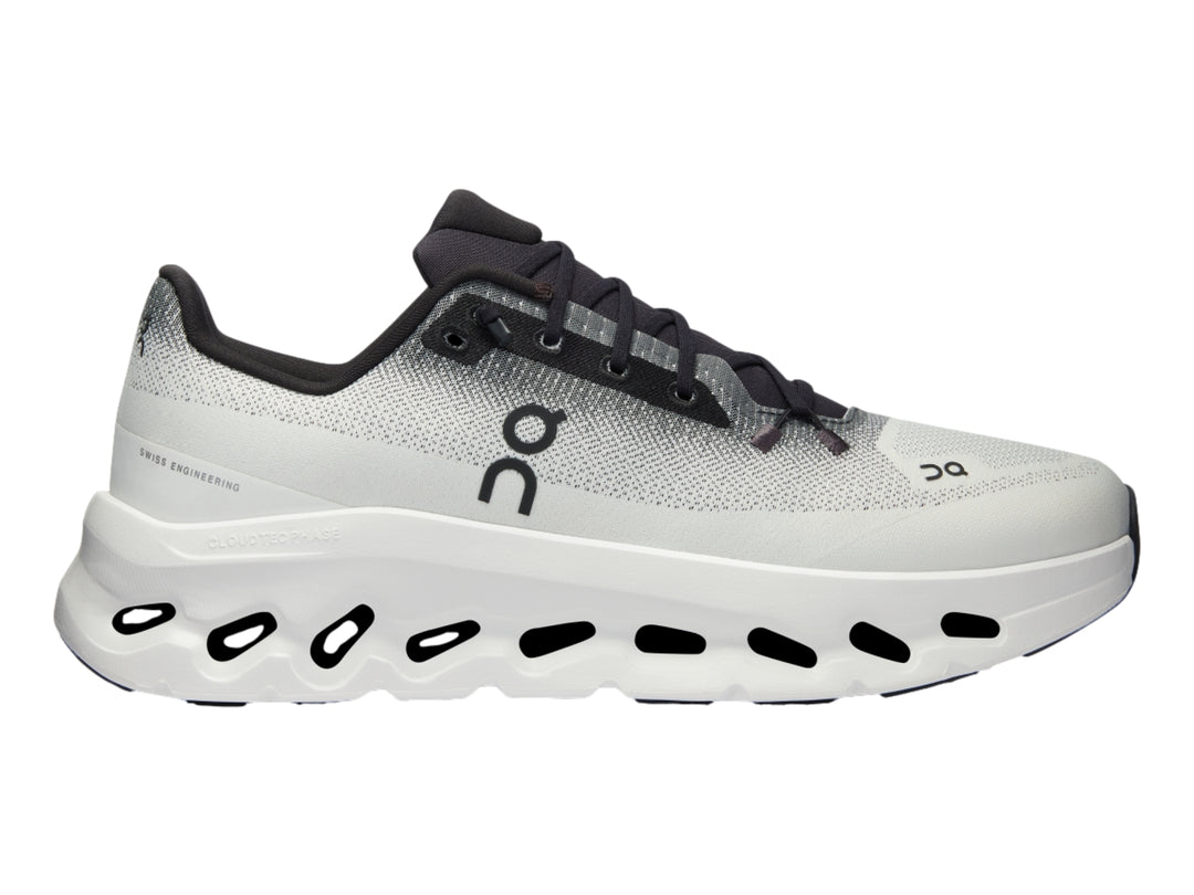 Tenis deportivos On Cloud en color marfil con detalles en negro y suela blanca con diseño de nubes.