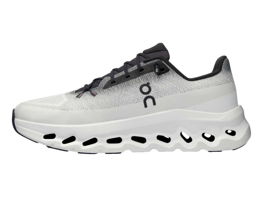 Tenis deportivos On Cloud en color marfil con detalles en negro y suela blanca con diseño de nubes.